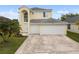 Two-story home with a three-car garage, arched entryway, and well-manicured lawn at 6714 Bouganvillea Crescent Dr, Orlando, FL 32809