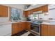 Well-lit kitchen with stainless steel appliances, wooden cabinets, and a view of the outdoors at 6714 Bouganvillea Crescent Dr, Orlando, FL 32809