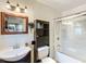 A bright bathroom featuring a vanity sink, mirrored cabinet, and a shower with glass doors at 690 W Pearl St, Bartow, FL 33830