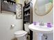Cozy bathroom featuring a pedestal sink, decorative mirror, and storage cabinet above the toilet at 690 W Pearl St, Bartow, FL 33830