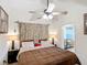 A bedroom featuring a ceiling fan, a decorative headboard, and comfortable bedding at 690 W Pearl St, Bartow, FL 33830