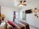 A cozy bedroom with a decorative bed, ceiling fan, and a wall-mounted television at 690 W Pearl St, Bartow, FL 33830