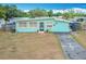 Charming single story home featuring a tidy front yard, paved driveway, and unique sky blue exterior at 690 W Pearl St, Bartow, FL 33830