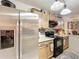 A view of a stainless steel refrigerator, black stove top and wood cabinets in the kitchen at 690 W Pearl St, Bartow, FL 33830