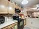 A kitchen featuring wood cabinets, a black stove, and views into the dining area at 690 W Pearl St, Bartow, FL 33830