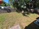View of the backyard area featuring a wooden fence and a mix of grass and leaves at 6937 Gibraltar Rd, Orlando, FL 32822
