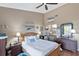 Vaulted ceiling bedroom with a beautiful wooden bed frame, view to the ensuite, and ample natural light at 7218 Alston Ct, Orlando, FL 32835