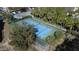 Aerial view of a tennis court showcasing its well-maintained blue and green surface and green net, surrounded by trees at 7544 Sunville Ave # 7544, Kissimmee, FL 34747