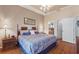 Comfortable bedroom features wood floors, large bed, and view into the bathroom at 801 Ashton Dr, Davenport, FL 33837
