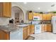 Bright and tidy kitchen features wood cabinets, white appliances, and ample counter space at 801 Ashton Dr, Davenport, FL 33837