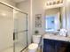 Modern bathroom featuring a glass enclosed shower, granite vanity, and decorative artwork at 8039 Oak Shadow Ct, Davenport, FL 33837