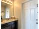 Bathroom featuring a vanity with granite countertop, decorative mirror, and white door at 8039 Oak Shadow Ct, Davenport, FL 33837