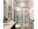 Bathroom with a vanity, granite counters, and a shower with glass doors at 8039 Oak Shadow Ct, Davenport, FL 33837