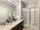 Bathroom features a glass-enclosed shower, double sinks with granite countertop, and modern fixtures at 8039 Oak Shadow Ct, Davenport, FL 33837