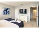 Neutrally designed bedroom with dresser, mounted TV, and ensuite bathroom entrance at 8039 Oak Shadow Ct, Davenport, FL 33837