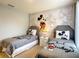 Charming bedroom featuring twin beds with playful Mickey Mouse-themed decor and a whimsical mural at 8039 Oak Shadow Ct, Davenport, FL 33837