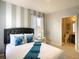 Comfortable bedroom featuring a queen bed, stylish striped wall, and ensuite bathroom at 8039 Oak Shadow Ct, Davenport, FL 33837