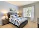 Bedroom with a queen-size bed, side tables, and a bright window at 8039 Oak Shadow Ct, Davenport, FL 33837