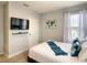 Neutral bedroom featuring a mounted TV, white curtains, and a comfortable queen-sized bed at 8039 Oak Shadow Ct, Davenport, FL 33837