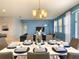 Open-concept dining area with a modern chandelier, seamlessly connects to the living room, bathed in natural light at 8039 Oak Shadow Ct, Davenport, FL 33837
