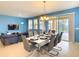 Open dining room with seating for eight, offering views of the living area and outdoor swimming pool at 8039 Oak Shadow Ct, Davenport, FL 33837
