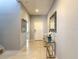 Light and bright entryway with neutral tile flooring, modern mirror, and a glass console table with decorative orchids at 8039 Oak Shadow Ct, Davenport, FL 33837
