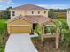 Inviting two-story home featuring a red tile roof, two-car garage, and manicured landscaping with palm trees at 8039 Oak Shadow Ct, Davenport, FL 33837