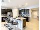 Well-equipped kitchen with sleek appliances, dark wood cabinets, granite countertops, and a center island with barstools at 8039 Oak Shadow Ct, Davenport, FL 33837