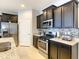 Well-equipped kitchen with stainless steel appliances, dark cabinetry, and granite countertops with a stylish tile backsplash at 8039 Oak Shadow Ct, Davenport, FL 33837