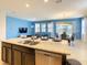 Bright kitchen with a large island, granite countertops, and stainless steel appliances open to dining and living area at 8039 Oak Shadow Ct, Davenport, FL 33837