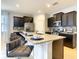 Spacious kitchen island with seating, granite countertops, and dark cabinets, ideal for casual dining and entertaining at 8039 Oak Shadow Ct, Davenport, FL 33837