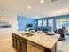 Open-concept kitchen featuring an island with seating, stainless steel appliances, and a seamless flow to the living area at 8039 Oak Shadow Ct, Davenport, FL 33837