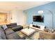 Comfortable living space with blue accent wall, modern furnishings, and a stylish area rug, perfect for relaxation at 8039 Oak Shadow Ct, Davenport, FL 33837