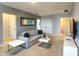 Cozy living room with a comfortable gray sofa, ottoman, and sleek entertainment center at 8039 Oak Shadow Ct, Davenport, FL 33837