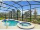 Inviting screened-in pool and spa area with a beautiful outdoor view; perfect for relaxation and entertaining at 8039 Oak Shadow Ct, Davenport, FL 33837