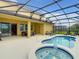 Outdoor living space includes a pool, spa, lounge chairs, and a covered patio for relaxation and entertaining at 8039 Oak Shadow Ct, Davenport, FL 33837