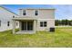 The backyard features a covered patio with a green grass lawn at 816 Lake Dell Rd, Dundee, FL 33838