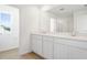 Well-lit bathroom features dual vanities, a large mirror, and ceramic floors at 816 Lake Dell Rd, Dundee, FL 33838