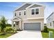 Two-story home showcasing neutral siding, gray roofing, an attached garage, and a manicured lawn at 816 Lake Dell Rd, Dundee, FL 33838