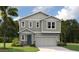 Charming two-story home with a gray exterior, a well-manicured lawn, and a spacious two-car garage at 816 Lake Dell Rd, Dundee, FL 33838