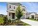 Two-story home featuring neutral siding, gray accents, an attached garage, and a well-manicured front yard at 816 Lake Dell Rd, Dundee, FL 33838