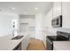 Well-lit kitchen featuring an island, stainless steel appliances, white cabinets and wood-style tile flooring at 816 Lake Dell Rd, Dundee, FL 33838