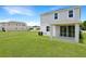 Exterior home view from the green backyard featuring a covered patio and open sight lines at 824 Lake Dell Rd, Dundee, FL 33838