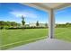 Covered patio area looking out to a spacious, green backyard with an open view at 824 Lake Dell Rd, Dundee, FL 33838