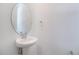 Elegant half-bath featuring a pedestal sink, modern faucet, and oval mirror at 824 Lake Dell Rd, Dundee, FL 33838