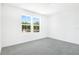 Light-filled bedroom with neutral carpet, white walls, and a pair of bright windows at 824 Lake Dell Rd, Dundee, FL 33838