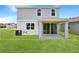 Back exterior of a two-story home with a covered patio overlooking the spacious green yard at 824 Lake Dell Rd, Dundee, FL 33838