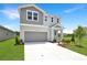 Stylish two-story home featuring gray exterior, a well-manicured lawn and concrete driveway at 824 Lake Dell Rd, Dundee, FL 33838