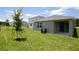 Expansive backyard shows off well-maintained lawn and the home's exterior with covered patio at 828 Lake Dell Rd, Dundee, FL 33838
