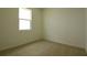 Bright bedroom features a large window and neutral carpeting, ready for your personal touch at 828 Lake Dell Rd, Dundee, FL 33838